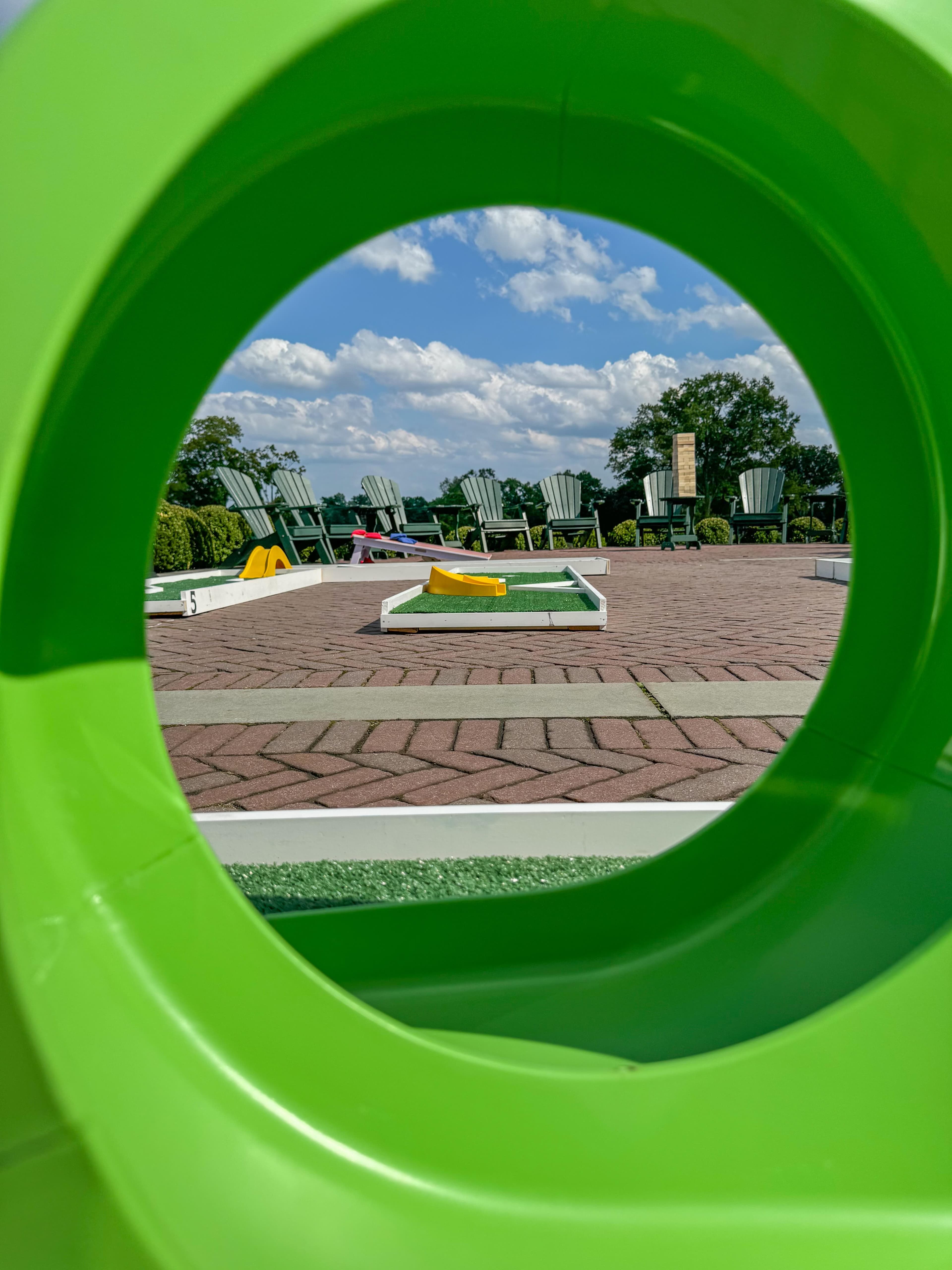 View through a green loop obstacle overlooking the mini golf course