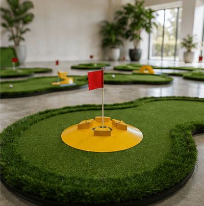 Indoor mini golf course with yellow hole and red flag
