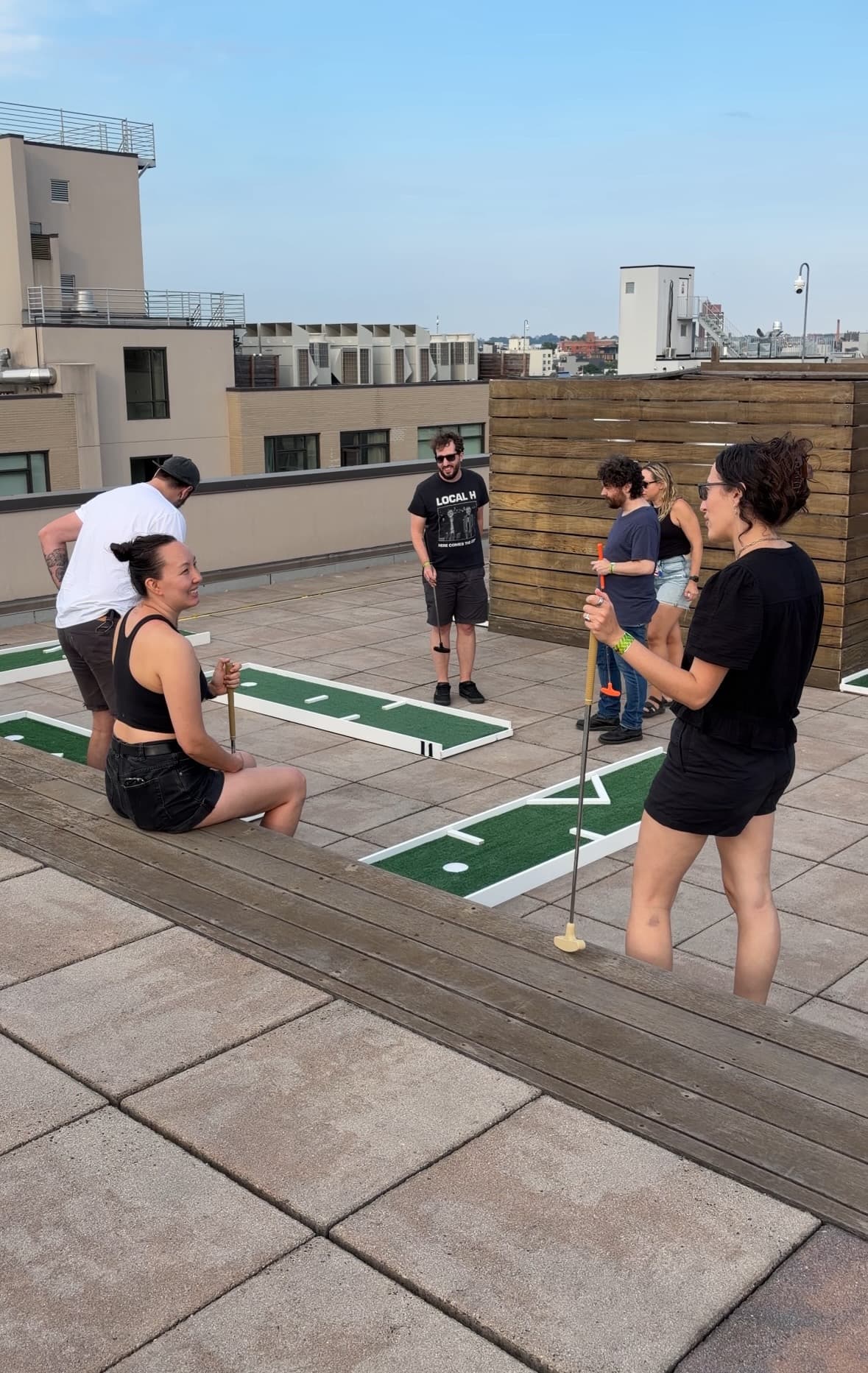 Friends playing mini golf at a rooftop party