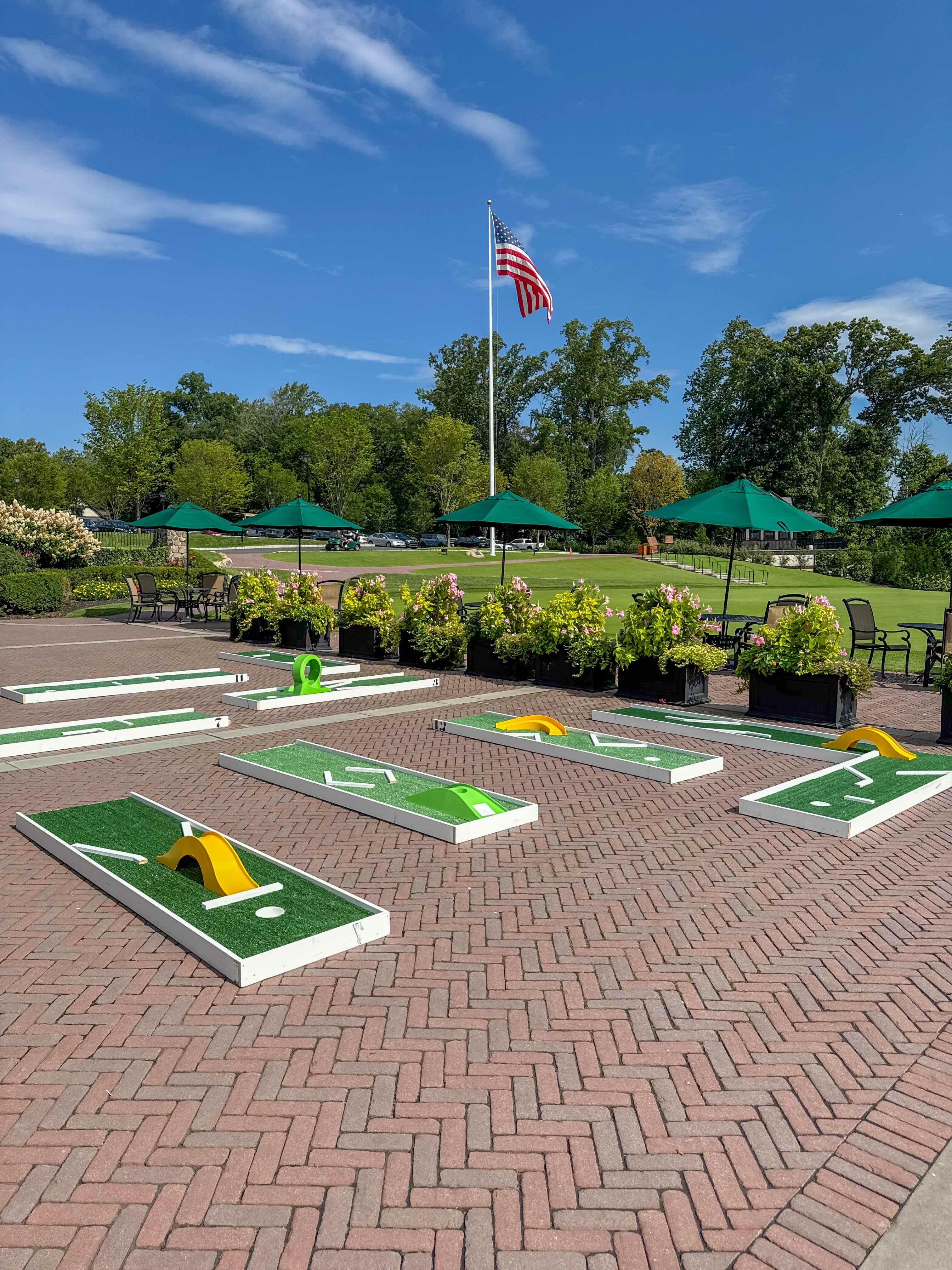 Aerial view of a country club patio mini golf course with clubhouse and flag